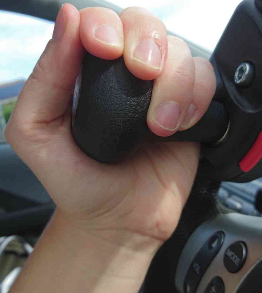 hand holding a steering spinner from the side